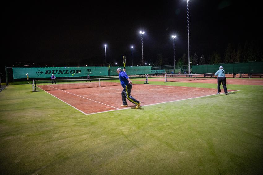 Mensen die tennissen op een tennisbaan